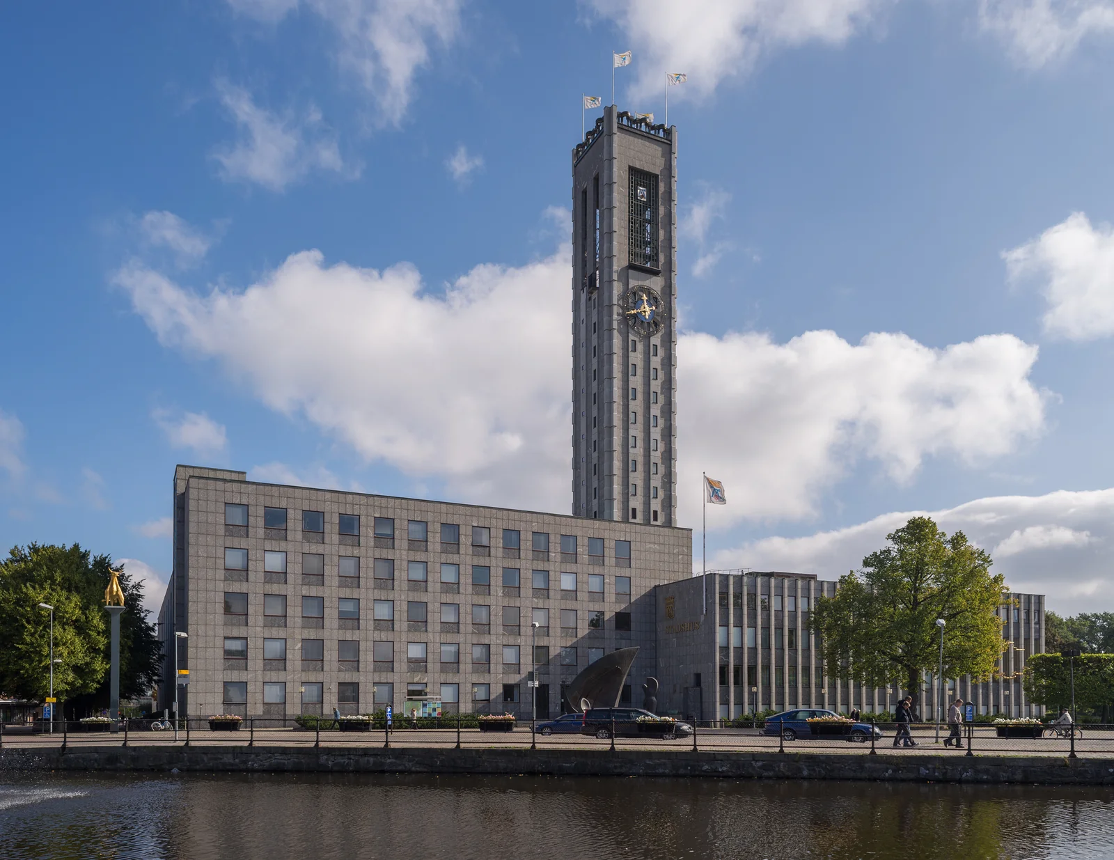 Västerås stadshus med klocktorn, fasad och Svartån i förgrunden.